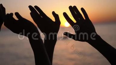 幸福的家庭<strong>举手</strong>。 双<strong>手举</strong>在空中，在夕阳的天空上剪影。